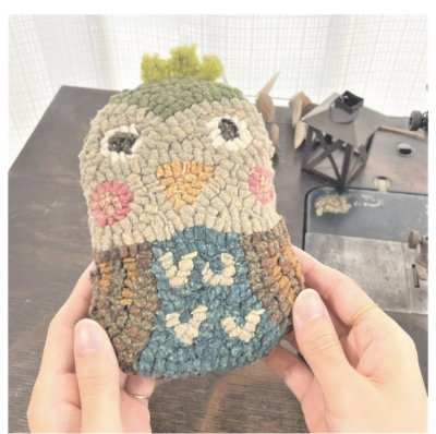 フックドラグで作った立体作品を両手で持っている様子